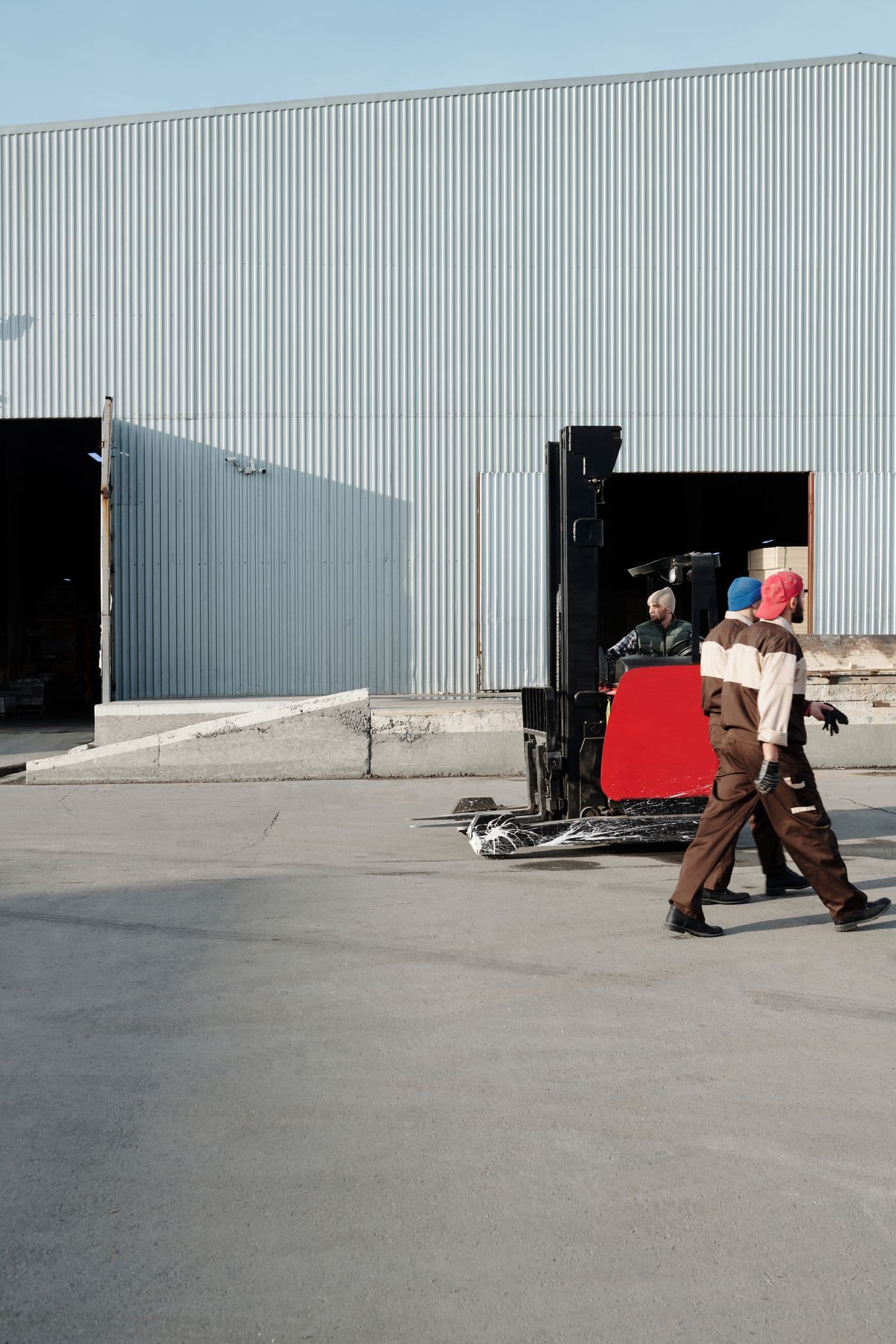 Warehouse team working beside a forklift outside a logistics facility